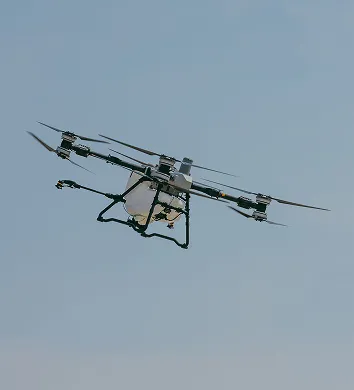 Agricultural spray drone flying in a clear sky