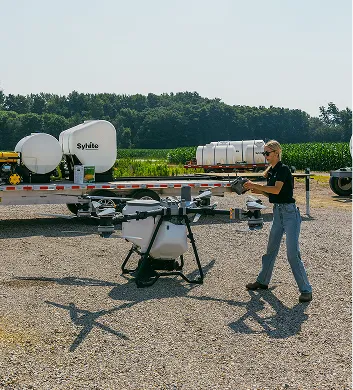 Sylvite team member preparing an agricultural drone beside a nurse trailer