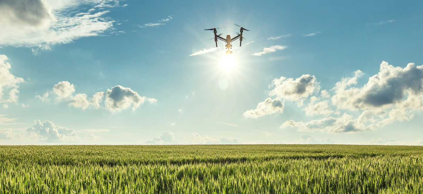 Agricultural drone flying over a green crop field